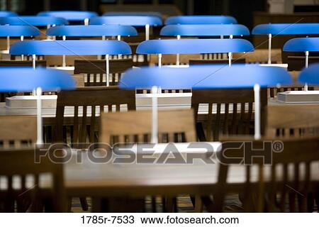 View of empty chairs and tables and rows of table lamps in the reading room of a library View Large Photo Image Stock Image - View of empty chairs and tables and rows of table lamps in the reading room of a library. Fotosearch
