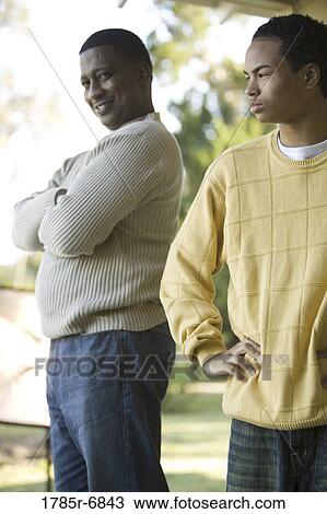 View of father standing next to teenage son View Large Photo Image Stock Image - View of father standing next to teenage son. Fotosearch