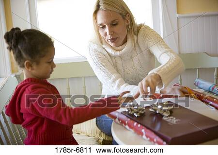 View of mother and daughter wrapping gifts View Large Photo Image Stock Image - View of mother and daughter wrapping gifts. Fotosearch