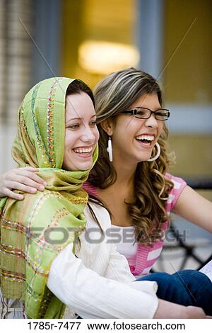 View of two cheerful young women outside a building View Large Photo Image Stock Photo - View of two cheerful young women outside a building. Fotosearch