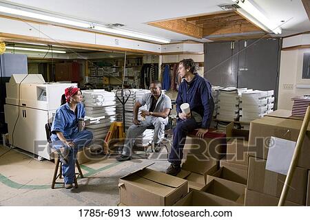 View of two men and a woman enjoying a coffee break while working in a warehouse View Large Photo Image Stock Image - View of two men and a woman enjoying a coffee break while working in a warehouse. Fotosearch