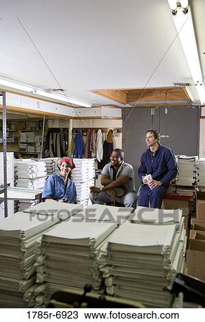 View of two men and a woman enjoying a coffee break while working in a warehouse View Large Photo Image Stock Image - View of two men and a woman enjoying a coffee break while working in a warehouse. Fotosearch