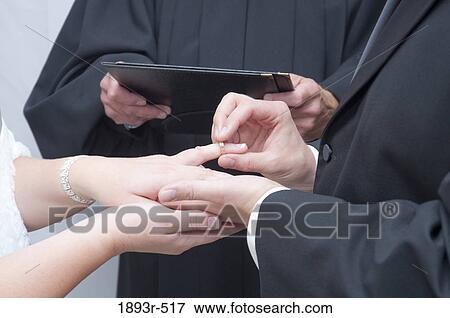 Wedding band being added to bride's finger View Large Photo Image Stock Photo - Wedding band being added to bride's finger. Fotosearch
