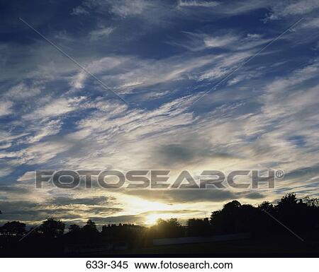 Wispy clouds in the sky during sunrise View Large Photo Image Stock Photography - Wispy clouds in the sky during sunrise. Fotosearch