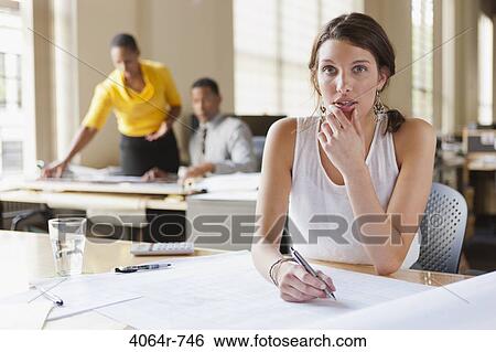 Woman at desk looking over plans View Large Photo Image Stock Photograph - Woman at desk looking over plans. Fotosearch