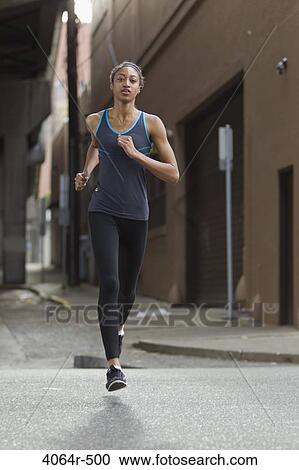 Stock Image - Woman jogging in street. Fotosearch
