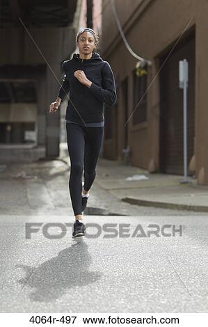 Woman jogging in street View Large Photo Image Stock Photo - Woman jogging in street. Fotosearch