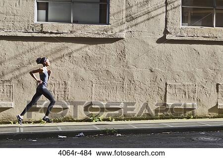 Woman jogging up street View Large Photo Image Picture - Woman jogging up street. Fotosearch