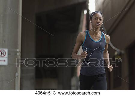 Woman listening to mp3 player while jogging View Large Photo Image Stock Image - Woman listening to mp3 player while jogging. Fotosearch