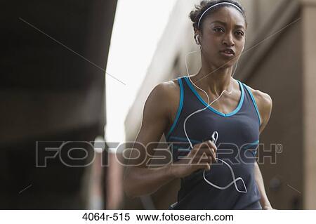 Woman listening to mp3 player while jogging View Large Photo Image Stock Photography - Woman listening to mp3 player while jogging. Fotosearch