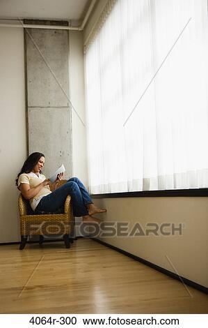 Woman reading book in loft apartment View Large Photo Image Stock Image - Woman reading book in loft apartment. Fotosearch