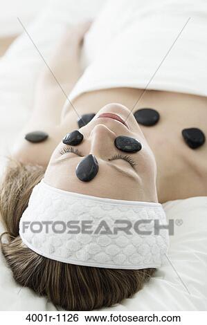Woman receiving hot stone therapy in spa View Large Photo Image Stock Photograph - Woman receiving hot stone therapy in spa. Fotosearch