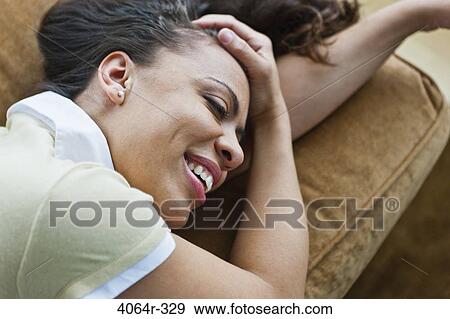 Stock Photo - Woman relaxing on couch. Fotosearch