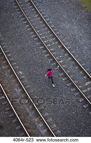 Woman running across railroad tracks View Large Photo Image Stock Image - Woman running across railroad tracks. Fotosearch