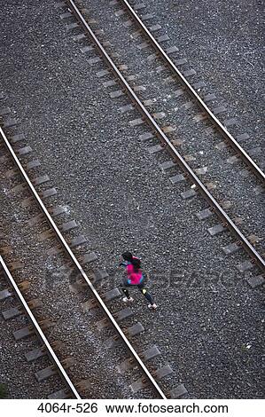 Woman running across railroad tracks View Large Photo Image Stock Photograph - Woman running across railroad tracks. Fotosearch