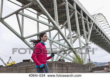 Woman running underneath bridge View Large Photo Image Picture - Woman running underneath bridge. Fotosearch