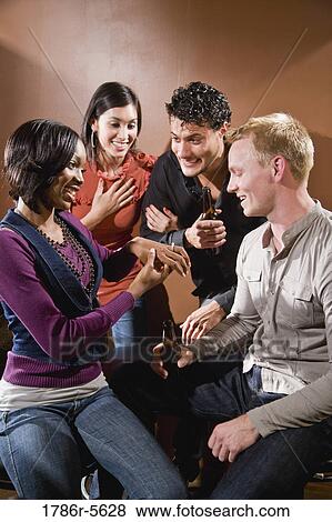 Woman showing off engagement ring to friends View Large Photo Image Stock Photo - Woman showing off engagement ring to friends. Fotosearch