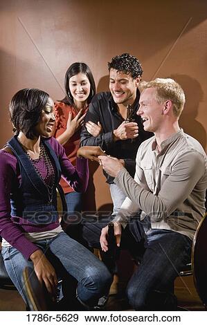 Stock Photo - Woman showing off engagement ring to friends. Fotosearch