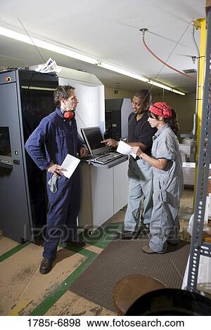 Workers being trained to use a piece of machinery with computer controls View Large Photo Image Stock Photo - Workers being trained to use a piece of machinery with computer controls. Fotosearch