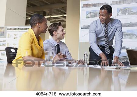 Workgroup collaborating on project at office View Large Photo Image Stock Photo - Workgroup collaborating on project at office. Fotosearch