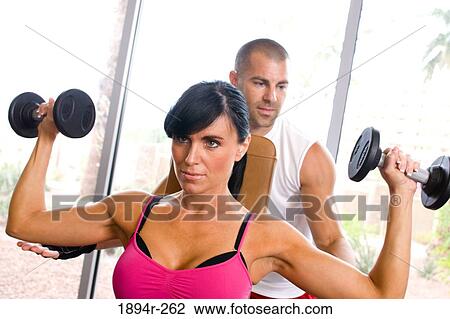 Young couple exercising in the gym of a tourist resort View Large Photo Image Stock Image - Young couple exercising in the gym of a tourist resort. Fotosearch