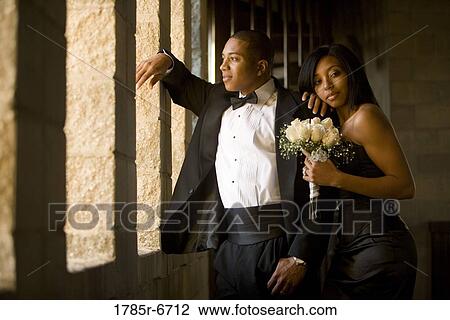 Young couple in formal attire holding white bouquet View Large Photo Image Stock Image - Young couple in formal attire holding white bouquet. Fotosearch