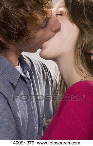 Young couple kissing each other View Large Photo Image Stock Photo - Young couple kissing each other. Fotosearch