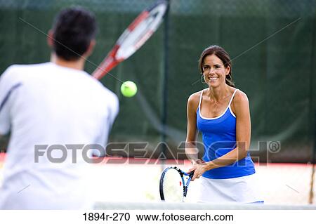 Young couple playing tennis in the court of a tourist resort View Large Photo Image Stock Image - Young couple playing tennis in the court of a tourist resort. Fotosearch