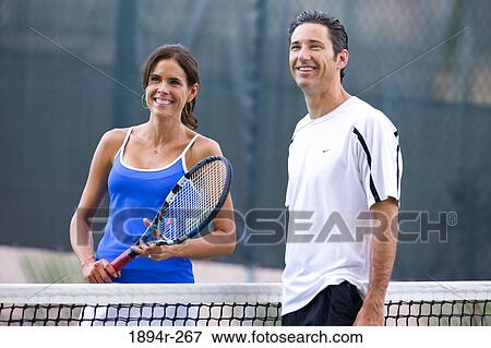 Young couple playing tennis in the court of a tourist resort View Large Photo Image Stock Photo - Young couple playing tennis in the court of a tourist resort. Fotosearch