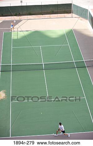 Young couple playing tennis in the court of a tourist resort View Large Photo Image Stock Photo - Young couple playing tennis in the court of a tourist resort. Fotosearch