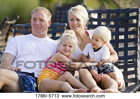 Young family on vacation relaxing on deck chairs View Large Photo Image Stock Image - Young family on vacation relaxing on deck chairs. Fotosearch