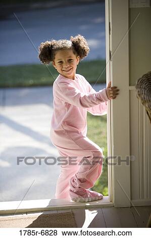 Young girl dressed in pajamas stepping out of the house through doorway View Large Photo Image Stock Photo - Young girl dressed in pajamas stepping out of the house through doorway. Fotosearch