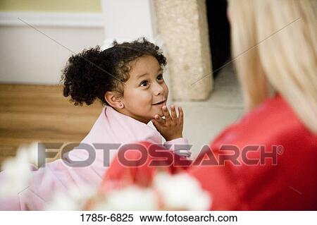 Young girl in pajamas looking up at her mother in foreground View Large Photo Image Stock Photography - Young girl in pajamas looking up at her mother in foreground. Fotosearch