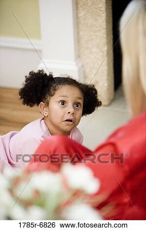 Young girl in pajamas looking up in surprise at her mother in foreground View Large Photo Image Stock Photograph - Young girl in pajamas looking up in surprise at her mother in foreground. Fotosearch
