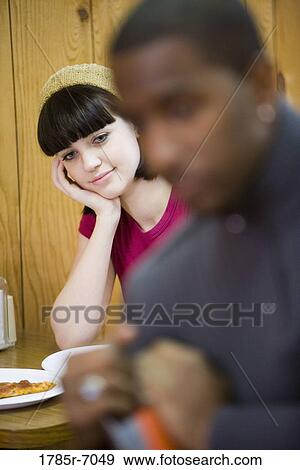 Young inter-racial couple sitting in a pizza parlor View Large Photo Image Stock Photo - Young inter-racial couple sitting in a pizza parlor. Fotosearch