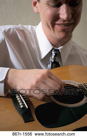 Young man playing the guitar View Large Photo Image Stock Photograph - Young man playing the guitar. Fotosearch