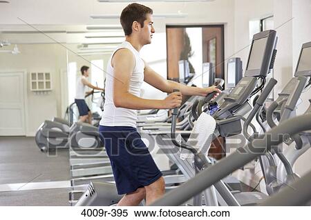 Stock Photography - Young man working out at gym. Fotosearch