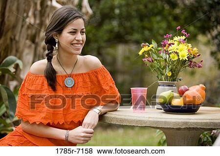 Young Mexican woman sitting at table View Large Photo Image Stock Photo - Young Mexican woman sitting at table. Fotosearch