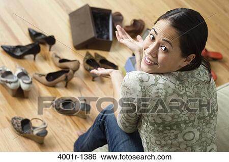 Young woman deciding which shoes to wear View Large Photo Image Stock Photograph - Young woman deciding which shoes to wear. Fotosearch