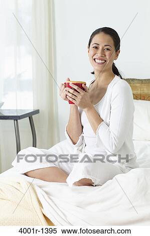 Young woman drinking coffee on the bed and smiling View Large Photo Image Stock Photography - Young woman drinking coffee on the bed and smiling. Fotosearch
