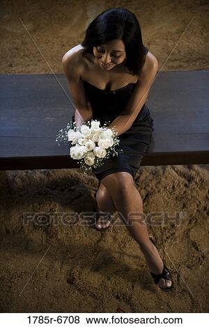 Young woman in black dress holding white bouquet View Large Photo Image Stock Photo - Young woman in black dress holding white bouquet. Fotosearch