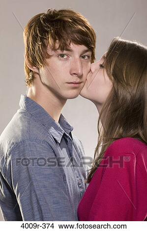 Picture - Young woman kissing a young man. Fotosearch