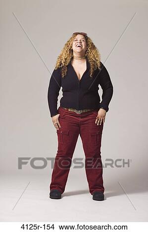 Young woman laughing with her hands in pockets View Large Photo Image Picture - Young woman laughing with her hands in pockets. Fotosearch