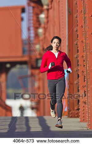 Young woman running along bridge View Large Photo Image Stock Image - Young woman running along bridge. Fotosearch