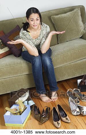 Young woman sitting on a couch near sandals View Large Photo Image Stock Photography - Young woman sitting on a couch near sandals. Fotosearch