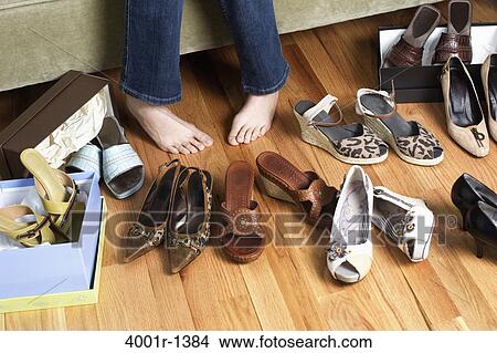 Young woman sitting on couch trying on shoes View Large Photo Image Picture - Young woman sitting on couch trying on shoes. Fotosearch