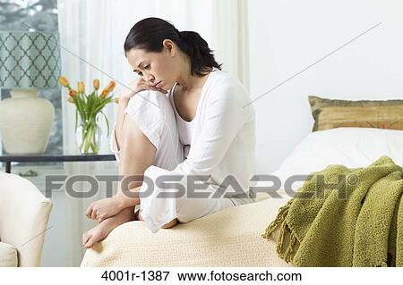 Young woman sitting on the bed and thinking View Large Photo Image Stock Photo - Young woman sitting on the bed and thinking. Fotosearch