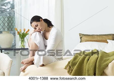Young woman sitting on the bed and thinking View Large Photo Image Stock Photo - Young woman sitting on the bed and thinking. Fotosearch