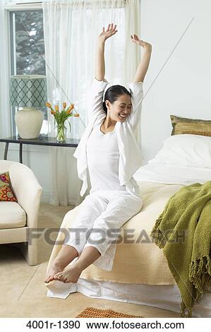 Young woman stretching on the bed View Large Photo Image Stock Image - Young woman stretching on the bed. Fotosearch
