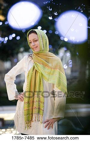 Young woman wearing a head scarf standing in a garden View Large Photo Image Stock Photography - Young woman wearing a head scarf standing in a garden. Fotosearch